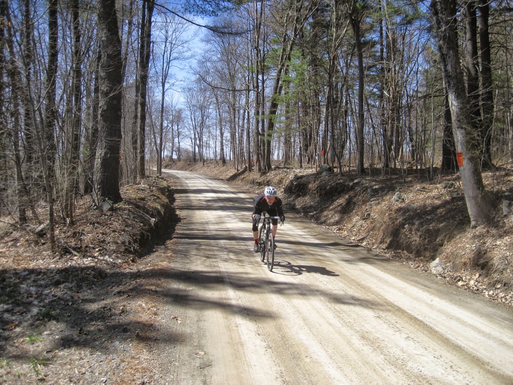 Don riding a dirt road descent.